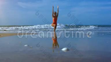 金发女郎站在沙滩海浪的沙滩上做瑜伽